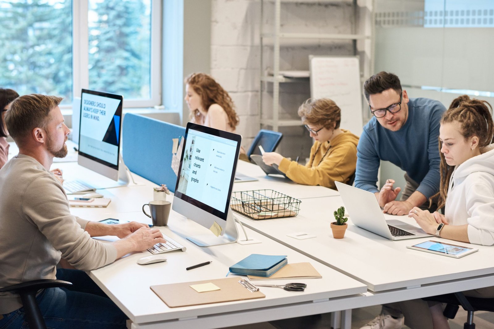 Young interns collaborating with colleagues in a bright modern office