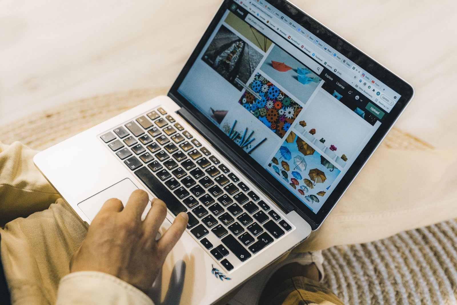 Person freelancing on a silver laptop in a cozy home setting