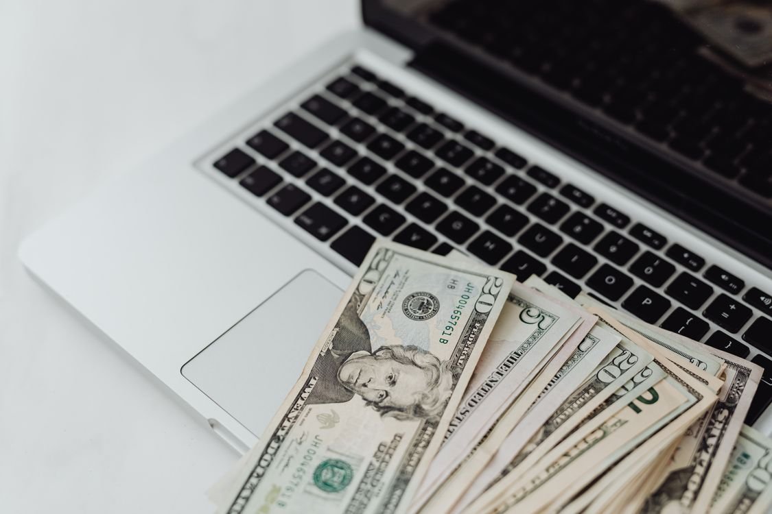 US dollar banknotes on a laptop keyboard representing receiving international payments online in Pakistan