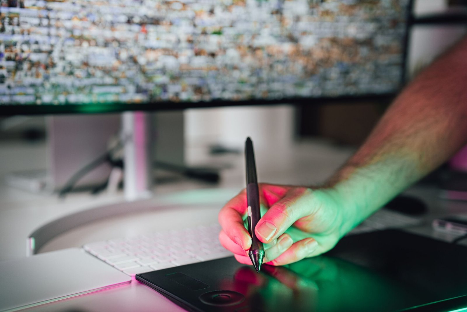 Graphic designer using a graphics tablet and stylus in a modern workspace
