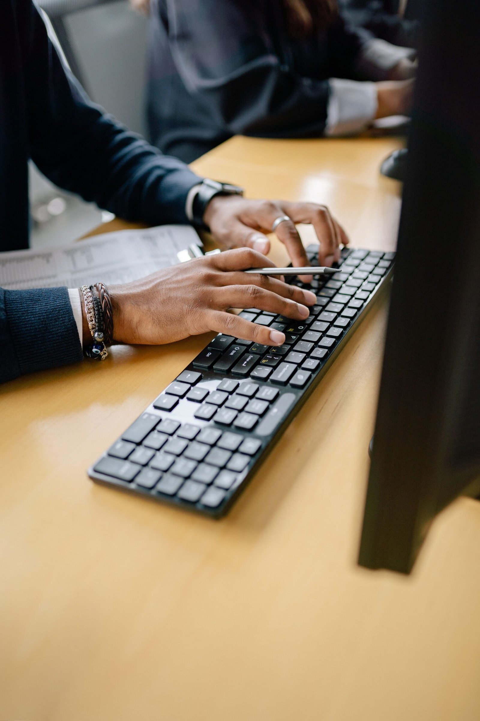 Person typing on a black keyboard doing data entry work