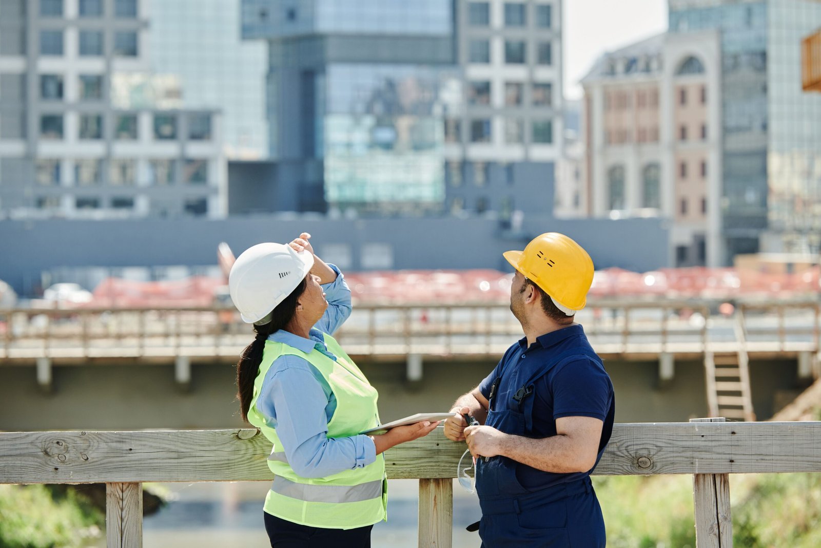 Two engineers reviewing architectural plans at a construction site, representing engineering jobs in Pakistan