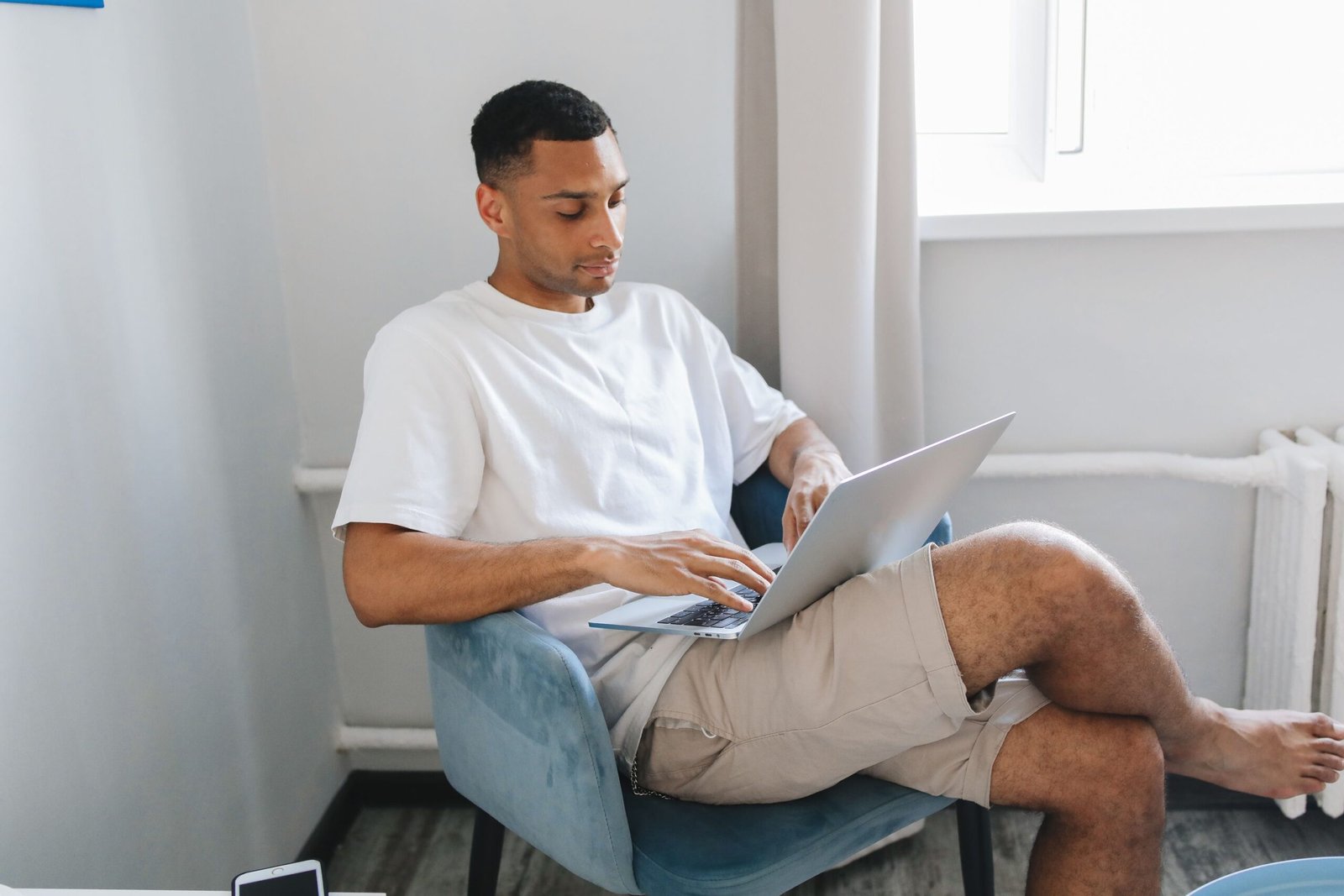 Young man working remotely on a laptop from home, representing remote jobs for Pakistanis hired by international companies