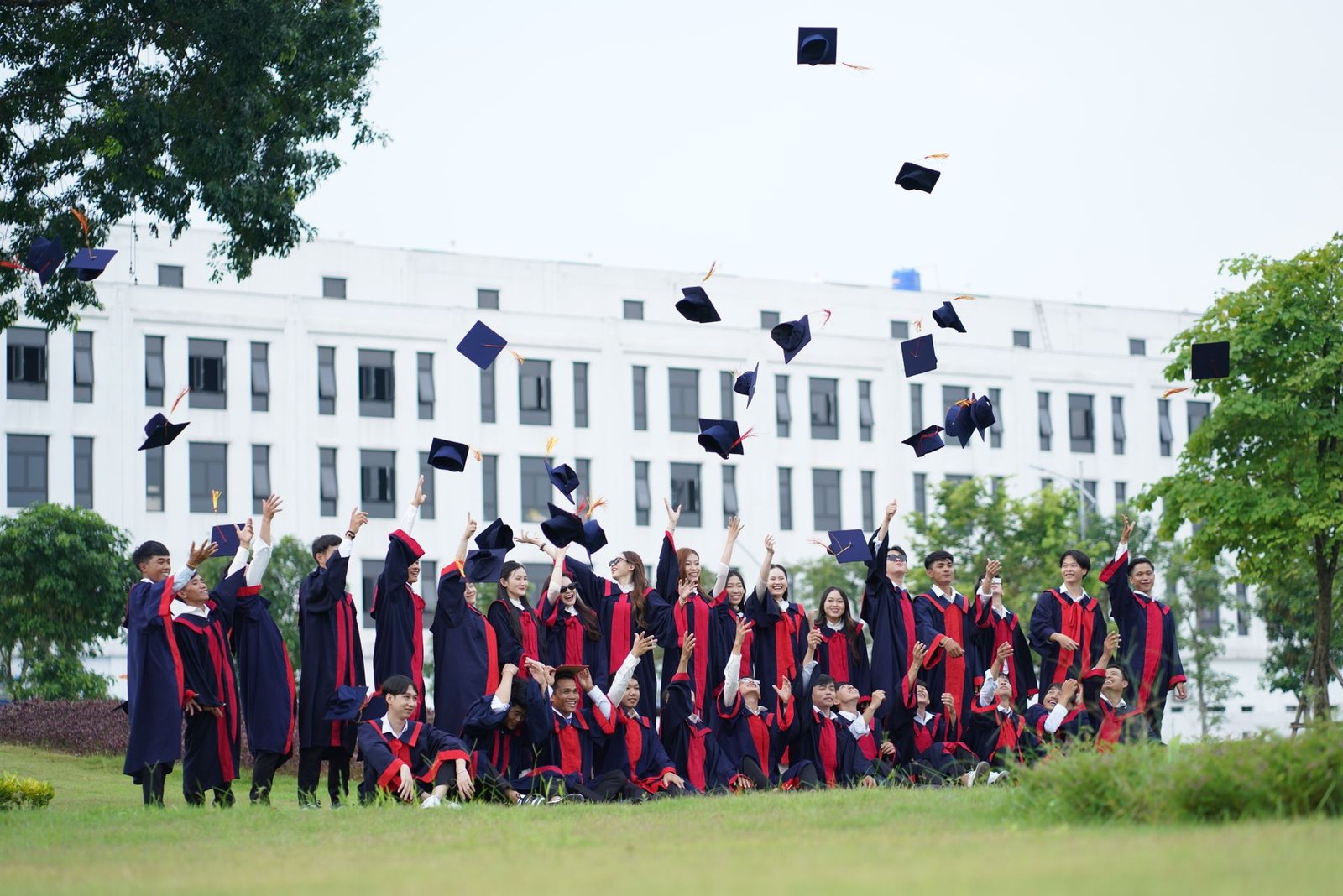 Happy fresh graduates throwing their caps in celebration