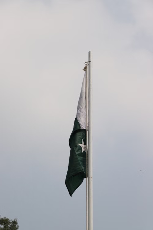 Pakistan national flag waving on a flagpole against the sky