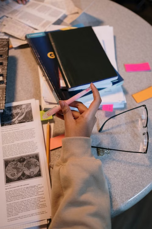Student preparing for FPSC exam in Pakistan with books and study notes