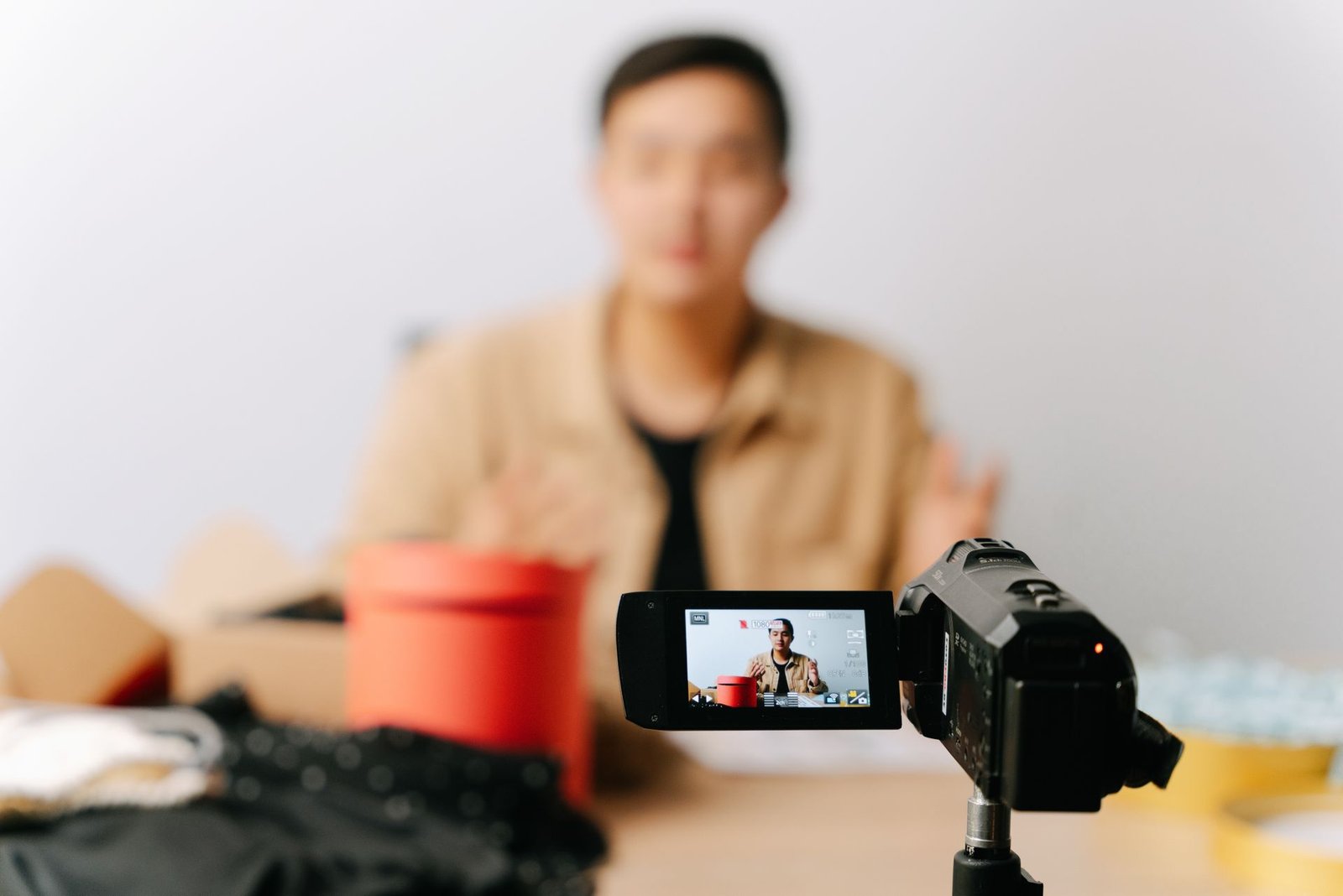 Content creator recording a YouTube video with a camera in a home studio